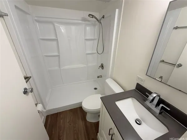 a bathroom with a sink a toilet and shower