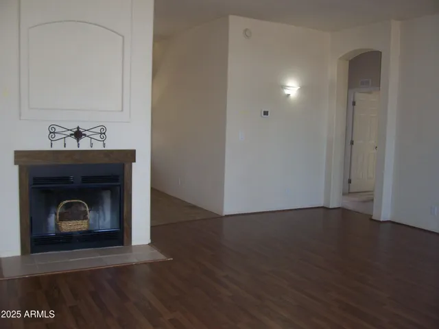 a view of a livingroom with wooden floor and a fireplace