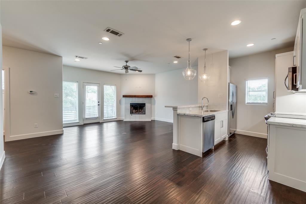 5830 Oram Street, Unit 5 Dallas, TX 75206 - Photo 17 of 18 a view of a kitchen and an empty room with wooden floor and a kitchen