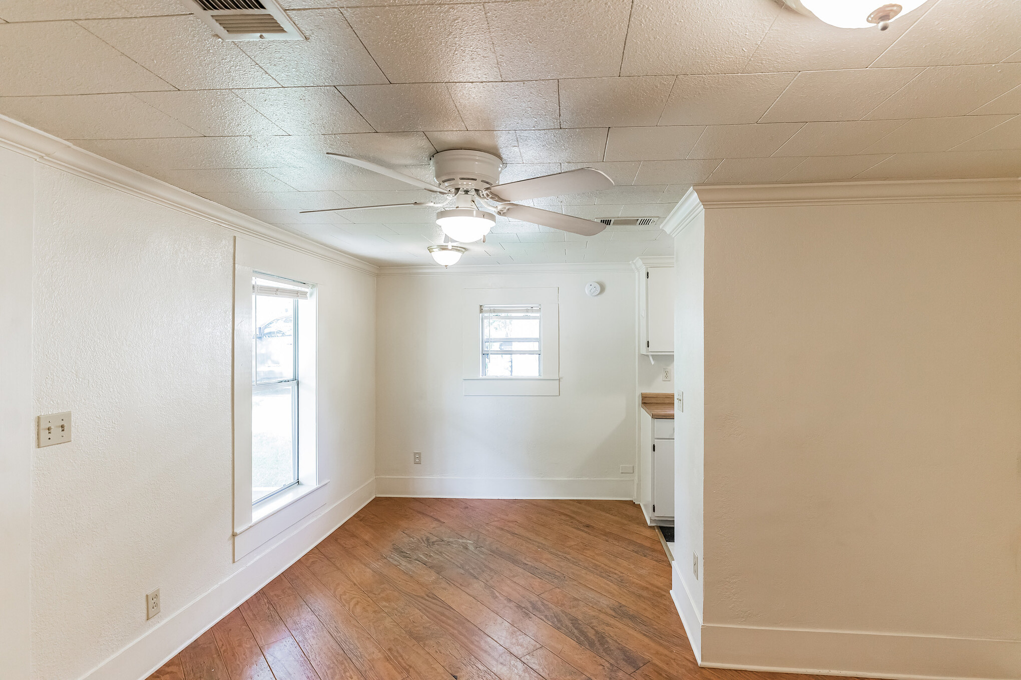 501 East 4th Street Georgetown, TX 78626 - Photo 7 of 25 Unfurnished room featuring a ceiling fan, light wood-style flooring, and crown molding