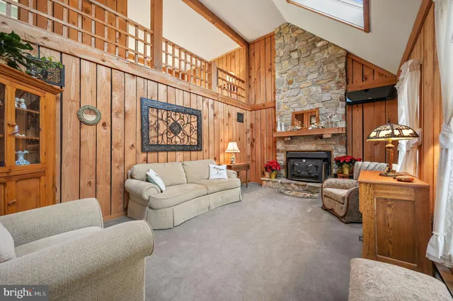 a living room with furniture a fireplace and a large window