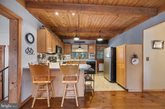 a dining room with granite countertop a table chairs and a refrigerator