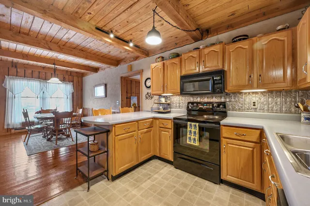 a kitchen with stainless steel appliances granite countertop a stove a sink dishwasher and a microwave oven with cabinets