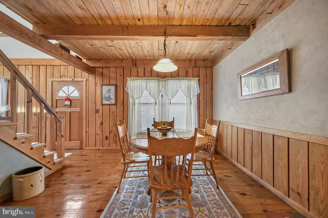 a dining room with furniture a chandelier and wooden floor
