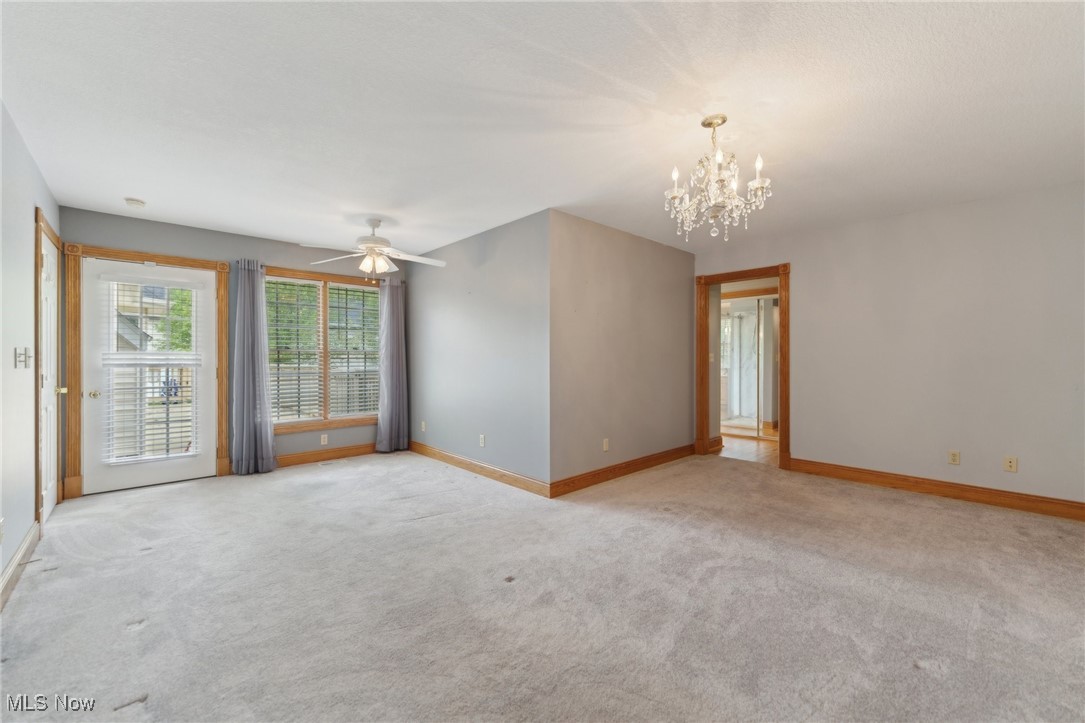45230 Cemetery Road Wellington, OH 44090 - Photo 17 of 50 Unfurnished room featuring light colored carpet, a chandelier, baseboards, and a ceiling fan