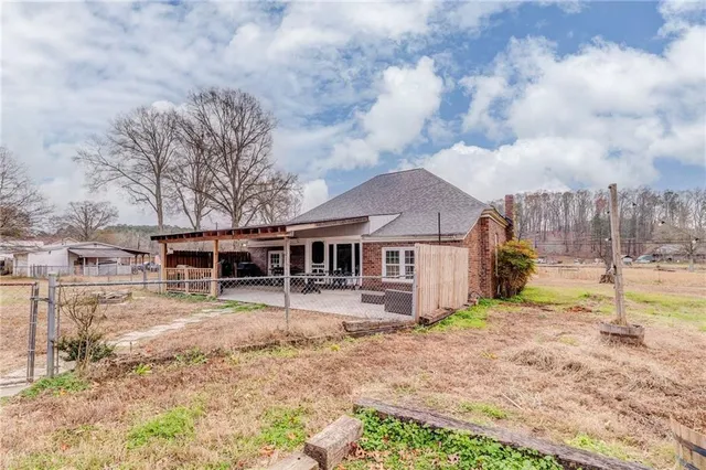 a view of a house with a big yard and large trees