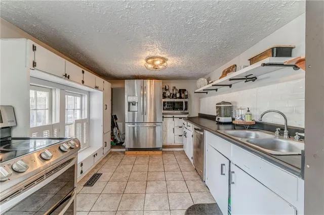a kitchen with stainless steel appliances granite countertop a sink and a white cabinets