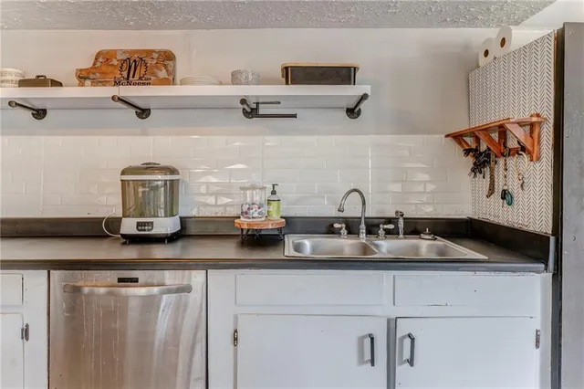 a kitchen with stainless steel appliances kitchen island granite countertop a stove and a sink
