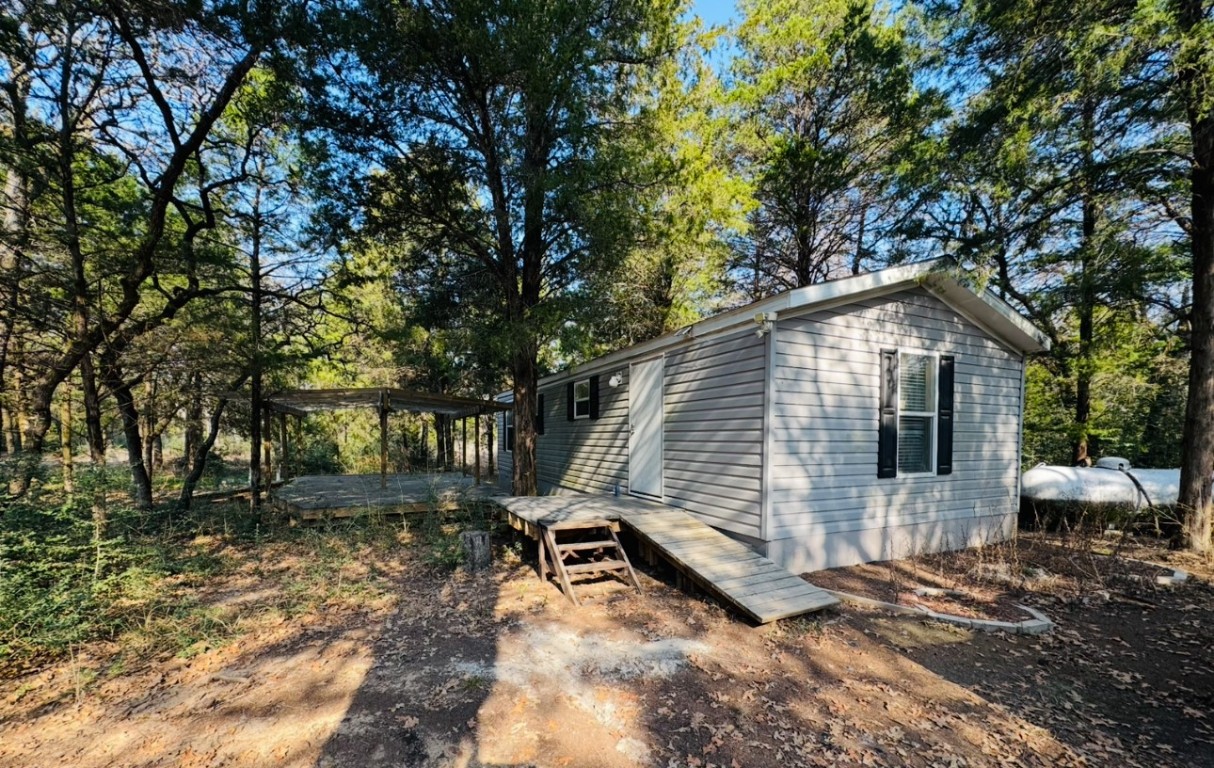 a view of backyard with a table and chair under an umbrella