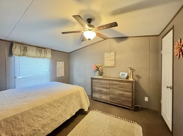 a bedroom with a bed and ceiling fan