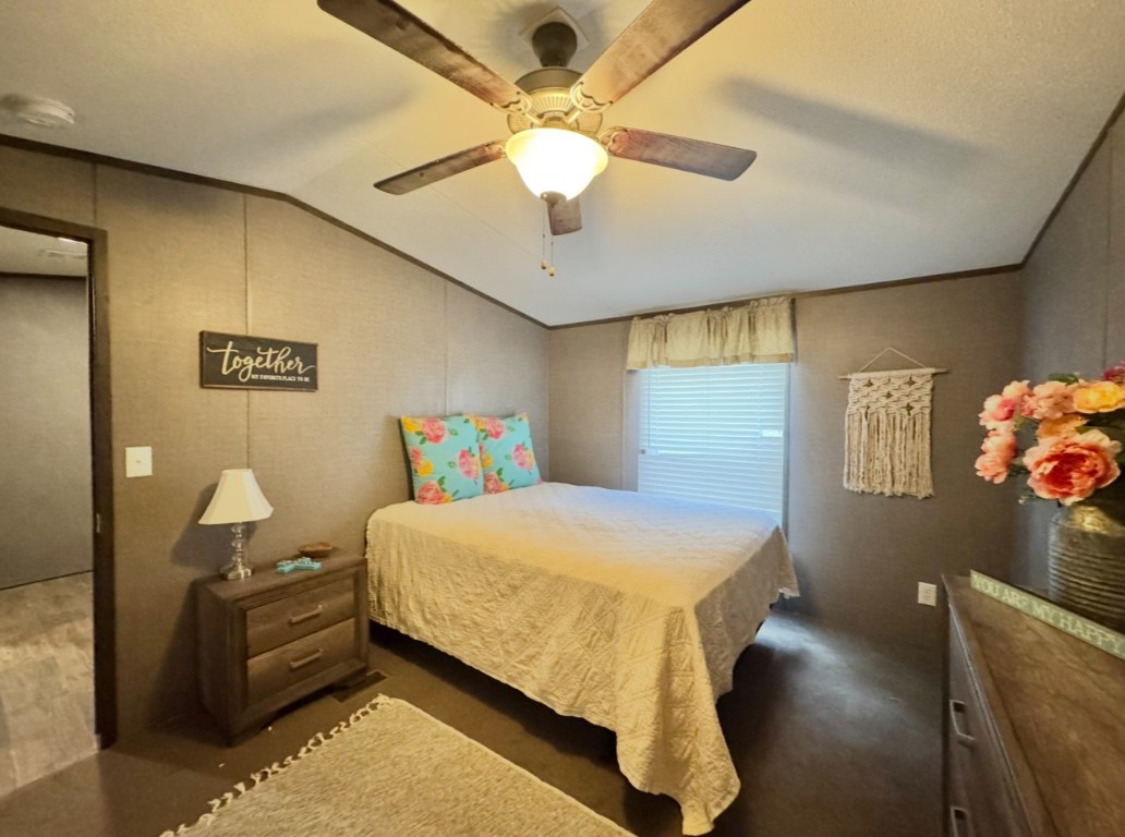 1575 County Rd B Lexington, TX 78947 - Photo 19 of 35 a bedroom with a bed and a chandelier