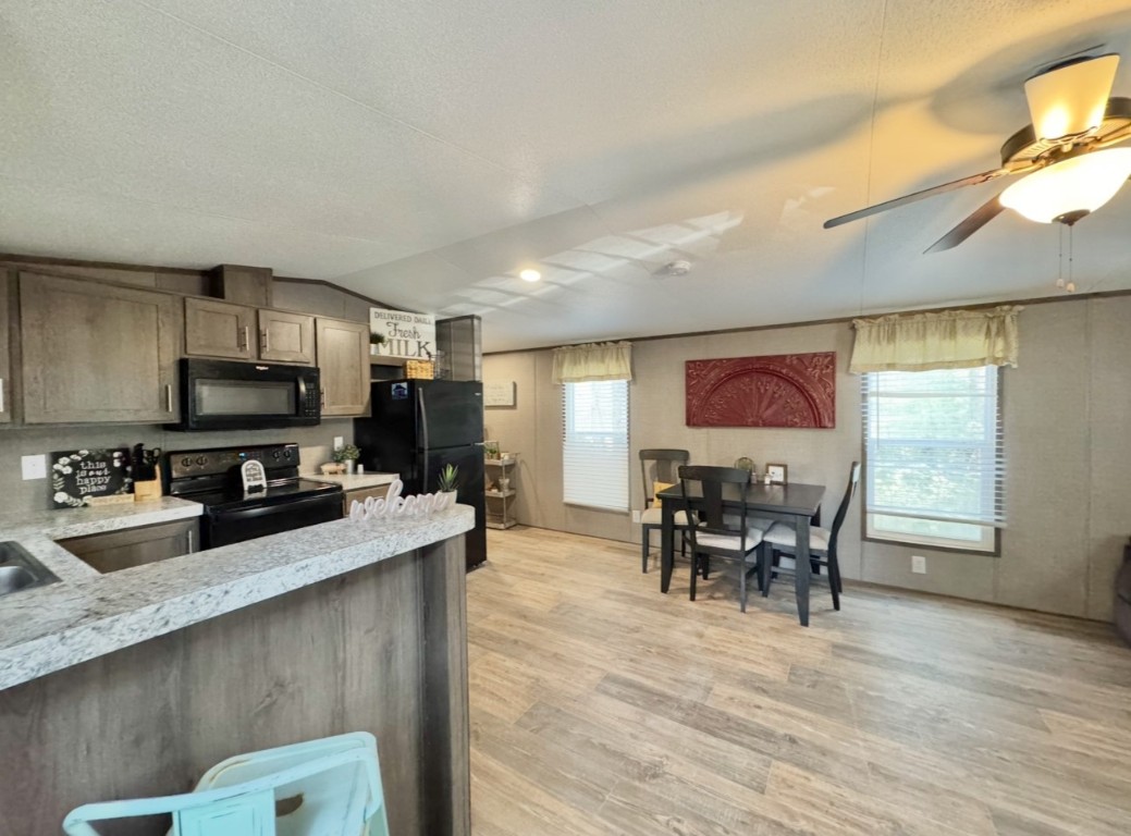 1575 County Rd B Lexington, TX 78947 - Photo 4 of 35 a kitchen with stainless steel appliances granite countertop a stove top oven a sink dishwasher a dining table and chairs with wooden floor