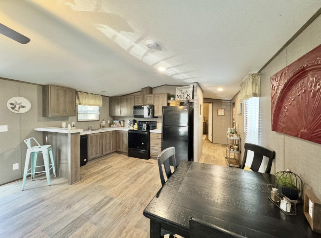 1575 County Rd B Lexington, TX 78947 - Photo 8 of 35 a open kitchen with stainless steel appliances a dining table chairs and a refrigerator