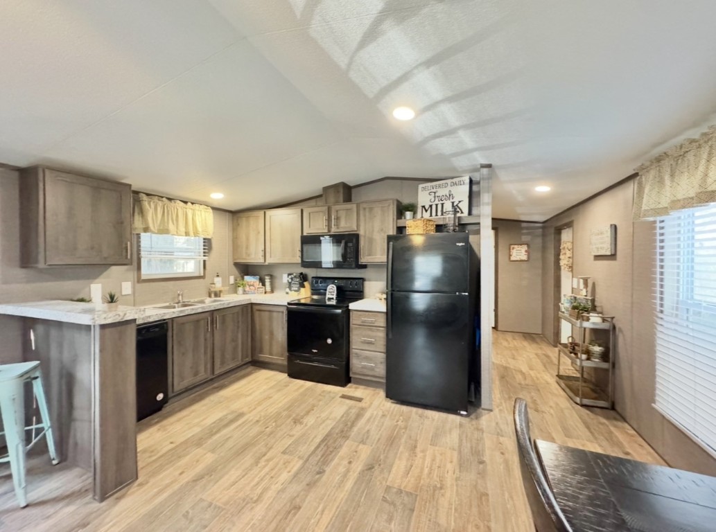 1575 County Rd B Lexington, TX 78947 - Photo 9 of 35 a kitchen with stainless steel appliances kitchen island granite countertop a refrigerator a sink dishwasher a stove with wooden cabinets and floor