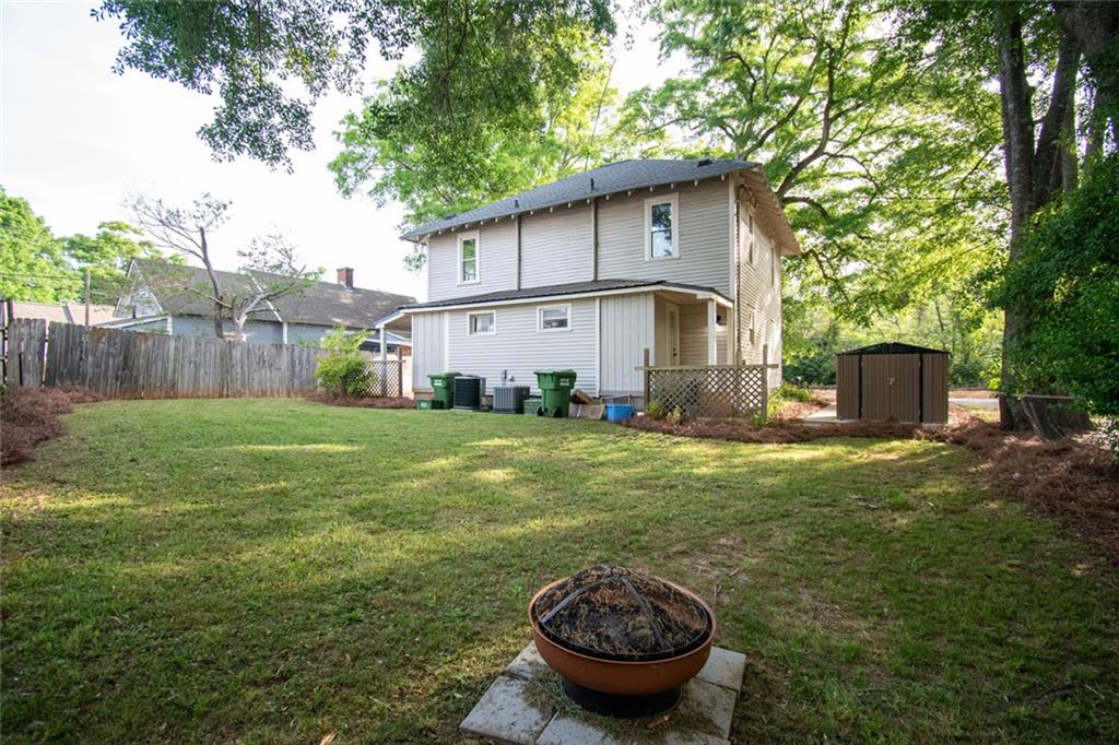 702 Radford Street Monroe, GA 30655 - Photo 47 of 49 a view of a backyard with table and chairs and wooden fence