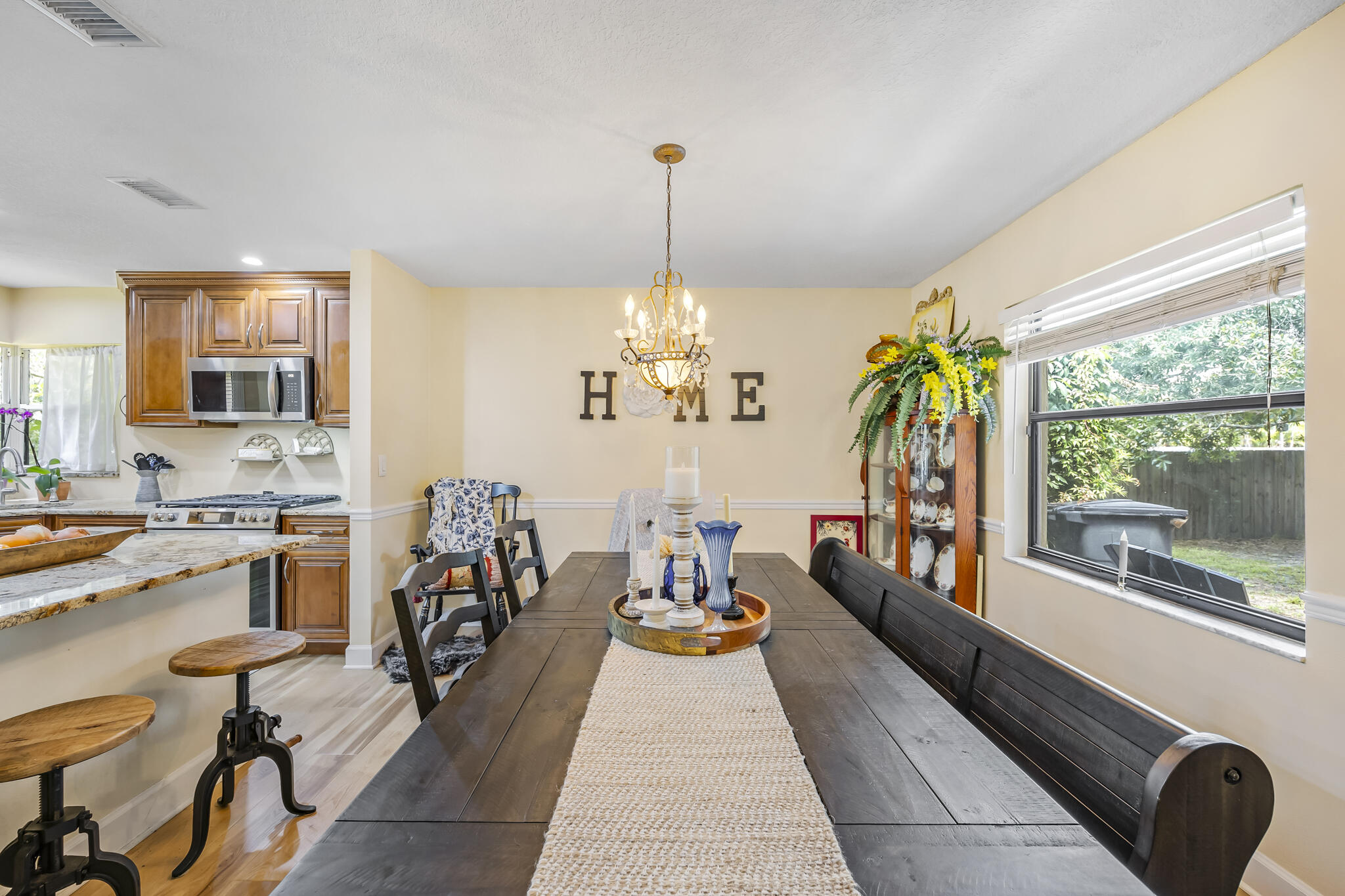 4650 Lake Washington Road Melbourne, FL 32934 - Photo 13 of 46 a dining room with furniture a chandelier and wooden floor