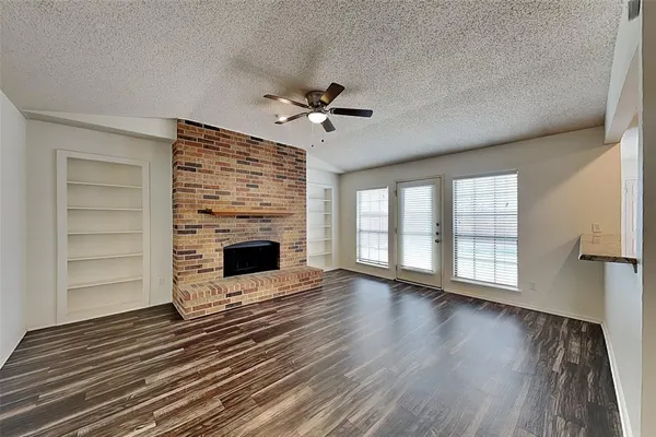 wooden floor fireplace and windows in an empty room