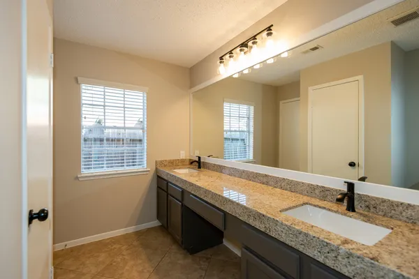 a bathroom with a granite countertop sink and a mirror