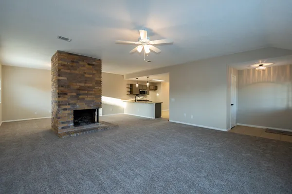 an empty room with a fireplace and fan
