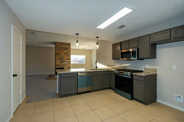 a large kitchen with cabinets and stainless steel appliances