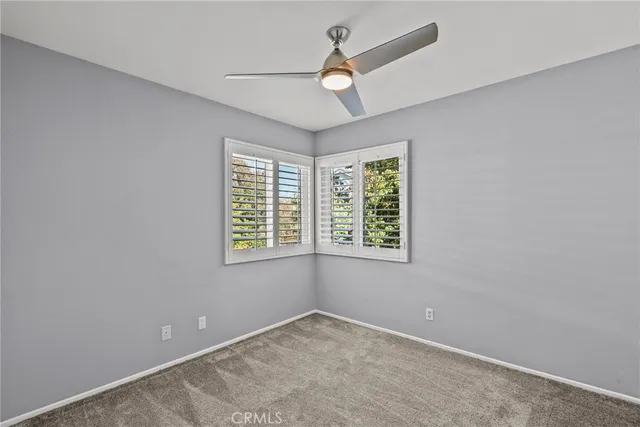 an empty room with a window and a fan