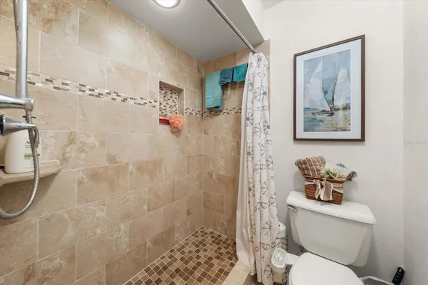a bathroom with a toilet a sink and shower