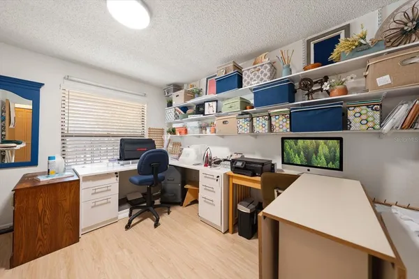 a view of a workspace with furniture and a window