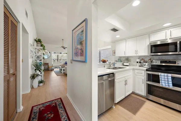 a kitchen with stainless steel appliances granite countertop a refrigerator and a stove top oven