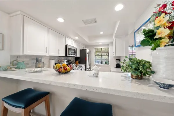 a kitchen with stainless steel appliances a sink a table and chairs