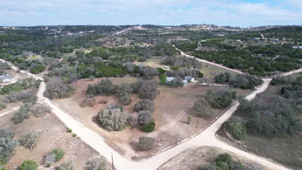 an aerial view of residential houses with outdoor space and trees