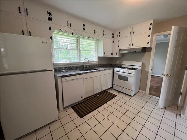 a kitchen with stainless steel appliances a sink a stove a refrigerator a window