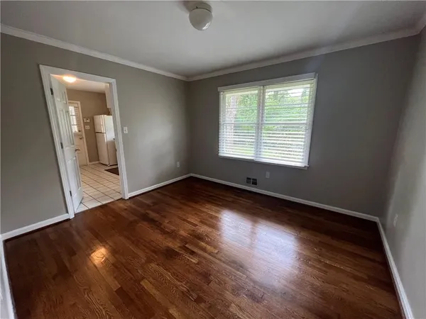 a view of a room with wooden floor and a window