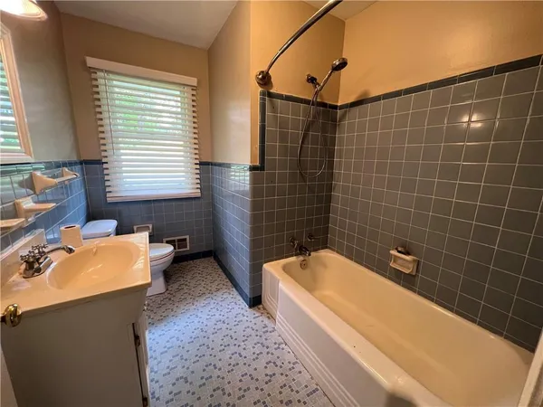 a bathroom with a bathtub sink and mirror