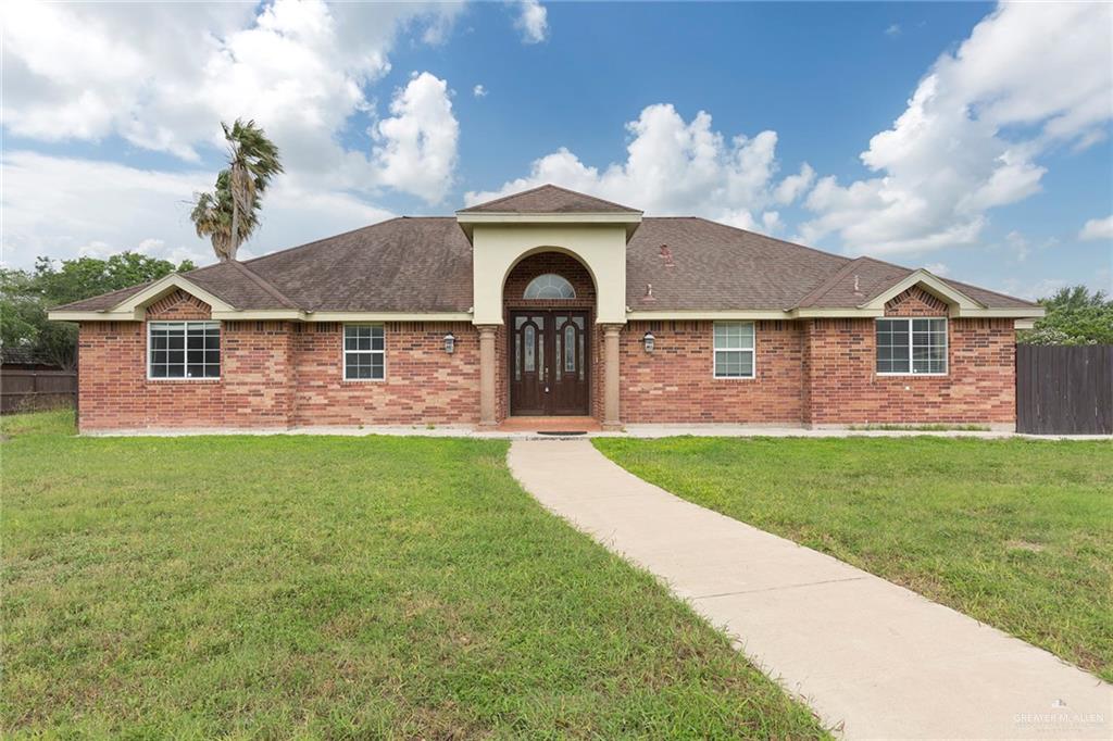 a front view of a house with a garden and yard