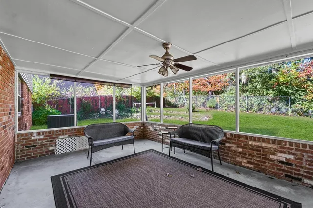 a kitchen with a sink a counter top space and living room view