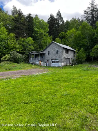 a view of a house with a yard and sitting area