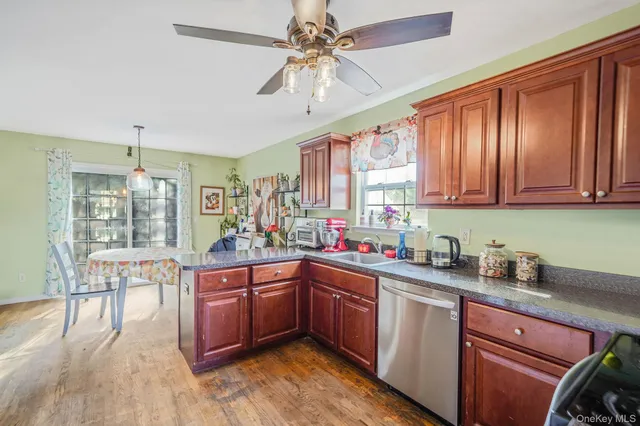 a kitchen with sink a window and wooden cabinets