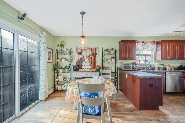 a living room with stainless steel appliances granite countertop furniture and a wooden floor