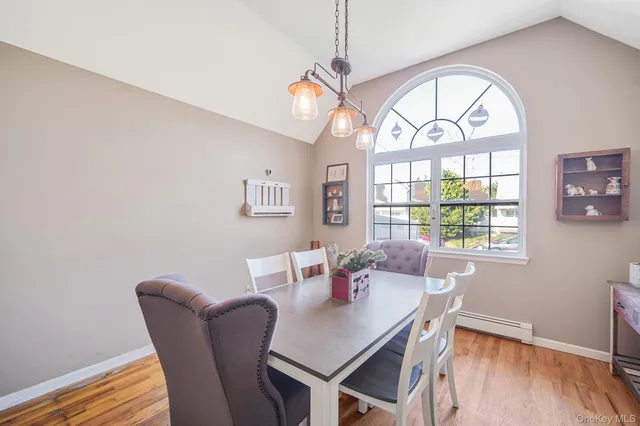 a view of a dining room with furniture a chandelier and wooden floor