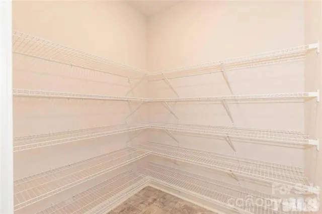 a view of a livingroom with a fireplace a ceiling fan and window