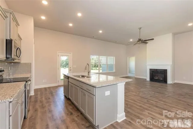 a kitchen with stainless steel appliances granite countertop a stove a sink and a refrigerator
