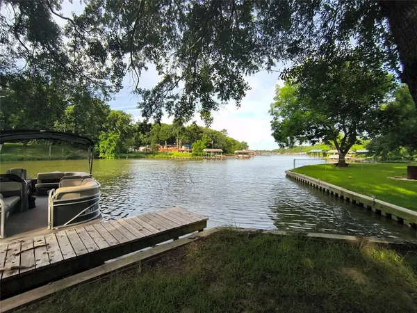 a view of a lake with couches and wooden fence