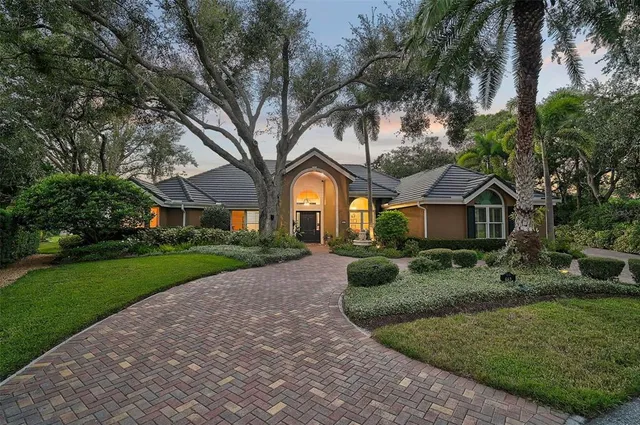a front view of a house with a garden and trees