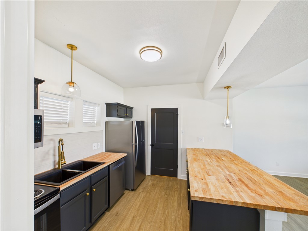 309 Mobile Avenue, Unit 4 Bryan, TX 77801 - Photo 11 of 12 a kitchen with stainless steel appliances granite countertop a sink stove and refrigerator