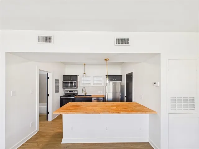 a large kitchen with stainless steel appliances a refrigerator and a stove