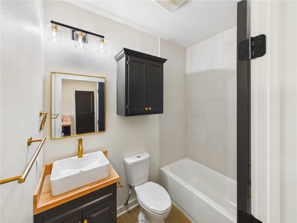 309 Mobile Avenue, Unit 4 Bryan, TX 77801 - Photo 10 of 12 a bathroom with a toilet a sink and mirror