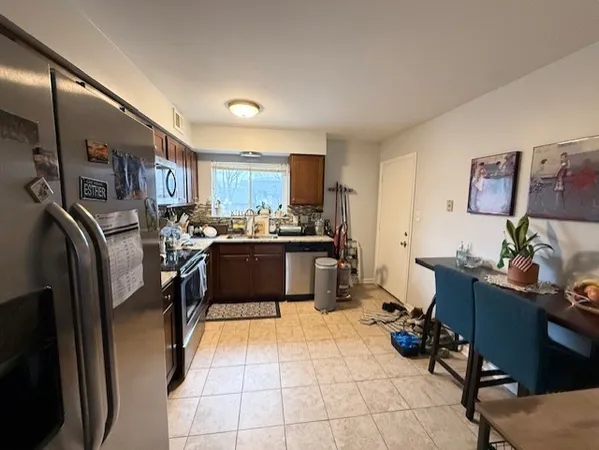 a kitchen with stainless steel appliances kitchen island granite countertop a refrigerator and a sink