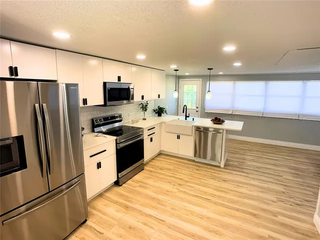 a kitchen with stainless steel appliances granite countertop a refrigerator sink and stove