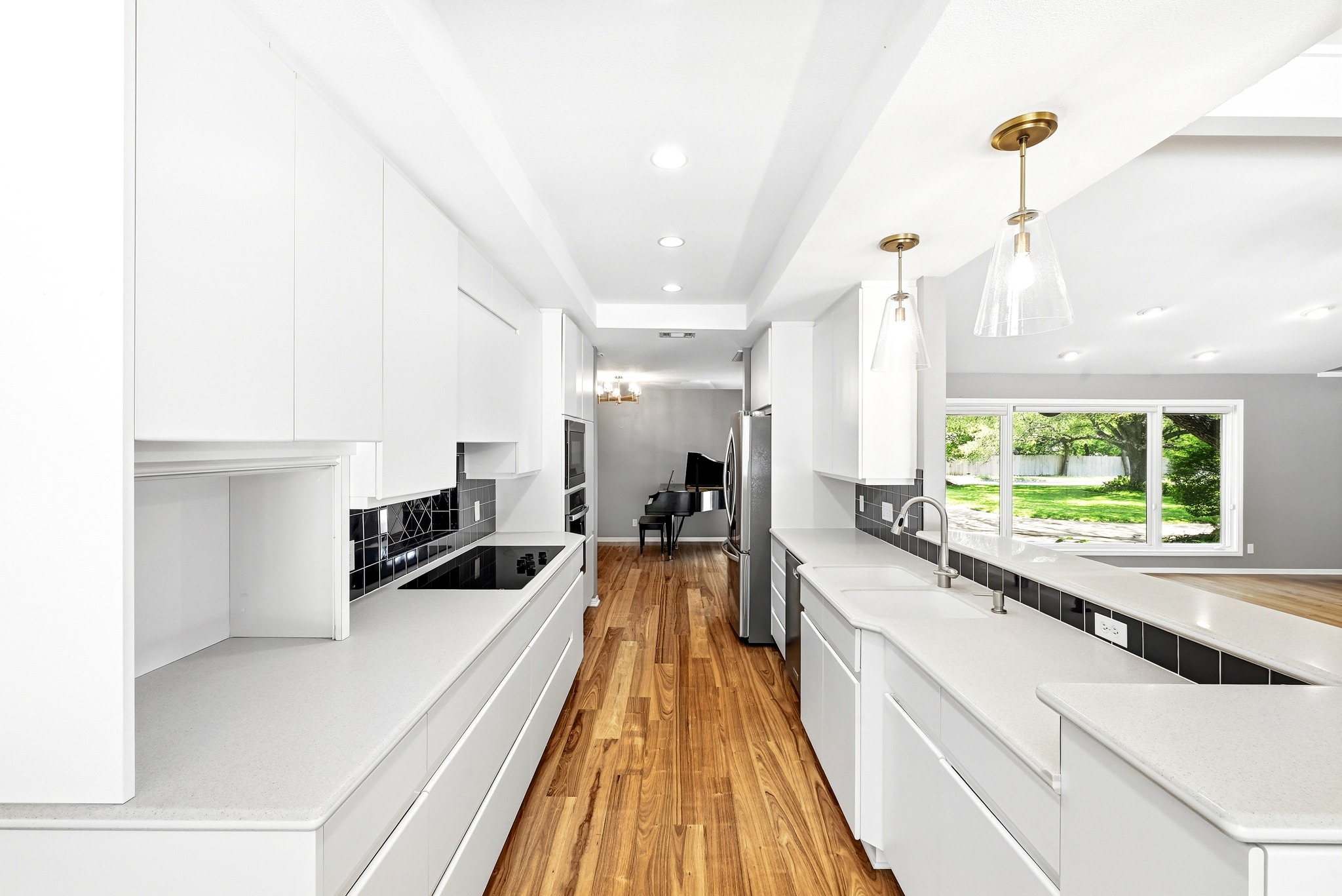 8608 Crest Ridge Circle Austin, TX 78750 - Photo 12 of 38 A galley kitchen boasts white cabinetry, built-in appliances, and natural hardwood flooring.