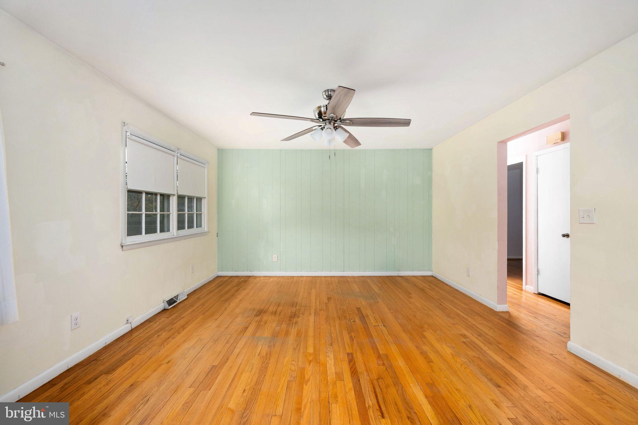 128 11th Street Colonial Beach, VA 22443 - Photo 23 of 80 a view of a big room with wooden floor and a ceiling fan